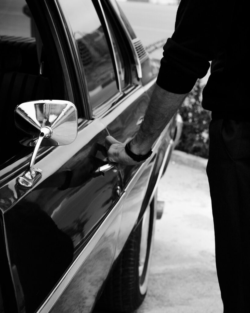 Chauffeur opening the door of a black car